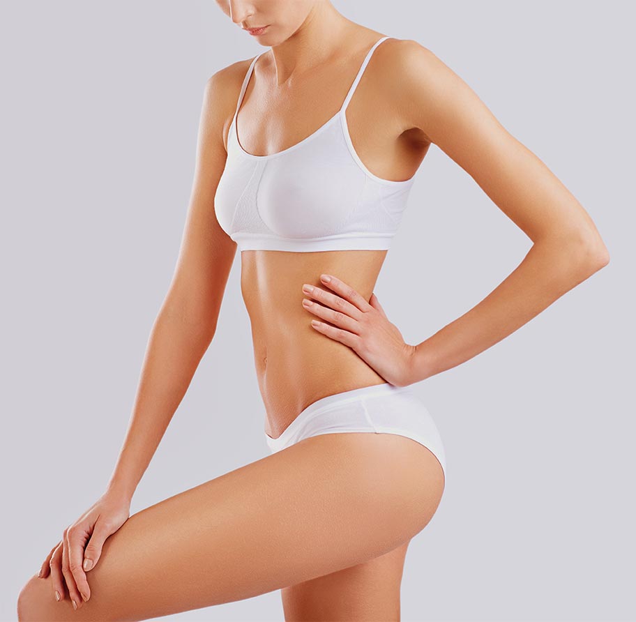 Slim body of a young woman in lingerie on a gray background.